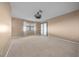 Spacious carpeted bedroom with ceiling fan and doors to patio at 6931 Se 54Th St, Ocala, FL 34472