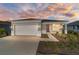One-story home with gray exterior, two-car garage, and landscaped yard at 9002 Sw 75Th Loop, Ocala, FL 34481