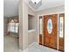 View of the foyer with a wooden door and tiled floor at 907 Se 65Th Cir, Ocala, FL 34472