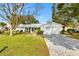 White house with gray roof, landscaped yard, and brick paver driveway at 10195 Se 178Th Pl, Summerfield, FL 34491