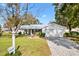 White house with gray roof, landscaped yard, and brick paver driveway at 10195 Se 178Th Pl, Summerfield, FL 34491