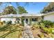 Front entrance of a white house with brick walkway and lush landscaping at 10195 Se 178Th Pl, Summerfield, FL 34491