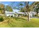 White house with gray roof, nicely landscaped yard, and a brick driveway at 10195 Se 178Th Pl, Summerfield, FL 34491
