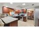 L-shaped kitchen with wood cabinets, granite countertops, and stainless steel appliances at 10195 Se 178Th Pl, Summerfield, FL 34491