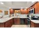 Modern kitchen with dark wood cabinets, granite countertops, and stainless steel appliances at 10195 Se 178Th Pl, Summerfield, FL 34491