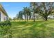Expansive backyard with lush grass and mature trees, overlooking a golf course at 13195 Se 93Rd Cir, Summerfield, FL 34491