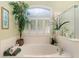 Relaxing bathroom with a large garden tub,plant and window with shutters at 13195 Se 93Rd Cir, Summerfield, FL 34491