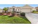 House exterior showcasing a two-car garage and neatly landscaped front yard at 13195 Se 93Rd Cir, Summerfield, FL 34491