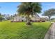 Landscaped lawn and partial view of single story home exterior with palm trees at 13195 Se 93Rd Cir, Summerfield, FL 34491