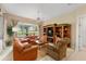 Relaxing living room with orange leather sofas and built-in shelving at 13195 Se 93Rd Cir, Summerfield, FL 34491
