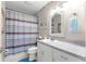 Bathroom with a shower/tub combo, striped shower curtain, and white vanity at 1610 Ne 38Th Ter, Ocala, FL 34470