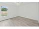 Empty bedroom with a window and grey wood-look flooring at 16691 Sw 30Th Terrace Rd, Ocala, FL 34473