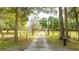 Long driveway entrance to a charming country estate with wooden posts and a sign at 2751 Ne 46Th St, Ocala, FL 34479