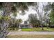 Front yard view of a white cottage with landscaping and a pergola at 2751 Ne 46Th St, Ocala, FL 34479