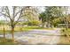 Gravel parking area surrounded by lush trees and a wooden fence at 2751 Ne 46Th St, Ocala, FL 34479