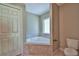 Bathroom with corner bathtub, toilet and double door closet at 5230 Nw 56Th Ter, Ocala, FL 34482