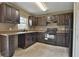 Dark wood cabinets, granite countertops, and black appliances at 5833 Nw 65Th St, Ocala, FL 34482