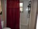 Clean bathroom with a shower stall and red curtain at 611 Sw Shorewood Dr, Dunnellon, FL 34431