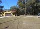 Yellow house with a brown garage door and large yard at 611 Sw Shorewood Dr, Dunnellon, FL 34431
