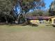 Landscaped yard with large oak trees and a chain link fence at 611 Sw Shorewood Dr, Dunnellon, FL 34431