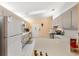 Galley kitchen with light colored cabinets and a large refrigerator at 9862 Se 179Th Pl, Summerfield, FL 34491
