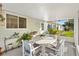 Cozy screened porch with patio furniture and lush landscaping at 9862 Se 179Th Pl, Summerfield, FL 34491