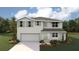 Two-story house with light gray siding, shutters, and landscaping at 10013 Se 161St Lane Rd, Summerfield, FL 34491