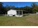 Home exterior view showing a screened porch and yard at 11064 Ne 212Th Ln, Fort Mc Coy, FL 32134