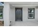 Dark gray front door with a glass window accent and a covered porch at 13457 Sw 107Th Pl, Dunnellon, FL 34432