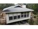 Elevated home with large windows and sunroom, wooden deck at 16510 Se 49Th Street Road, Ocklawaha, FL 32179