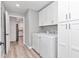 Laundry room features white cabinets and new washer and dryer set at 2809 Ne 43Rd Rd, Ocala, FL 34470