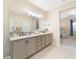 Double vanity bathroom with beige cabinets and a large mirror at 3977 Nw 46Th Ter, Ocala, FL 34482