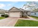 Two-car garage, brick paver driveway, and well-manicured lawn at 3977 Nw 46Th Ter, Ocala, FL 34482