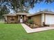 House exterior with walkway, landscaping, and a white garage door at 7090 Se 124Th Ln, Belleview, FL 34420