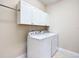 Laundry room with white cabinets, washer, and dryer at 7732 Sw 94Th Cir, Ocala, FL 34481