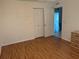 Well-lit bedroom featuring wood-look floors and double doors at 9117 Sw 93Rd Cir, Ocala, FL 34481