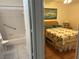 Bright bedroom with floral quilt and adjoining bathroom with shower/tub at 9117 Sw 93Rd Cir, Ocala, FL 34481