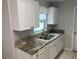 Modern kitchen with granite countertops and white cabinets at 9117 Sw 93Rd Cir, Ocala, FL 34481