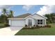 Single-story home with a two-car garage and landscaped yard at 9997 Se 161St Lane Rd, Summerfield, FL 34491