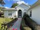 Front entrance with a walkway, landscaping, and a light blue door at 11147 Sw 68Th Ct, Ocala, FL 34476