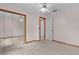 Large bedroom with mirrored closet doors and ceiling fan at 11852 Se 71St Ct, Belleview, FL 34420