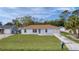 Single-story light blue house with brown roof and spacious yard at 11852 Se 71St Ct, Belleview, FL 34420