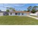 Light blue house with brown roof, landscaped yard, and screened porch at 11852 Se 71St Ct, Belleview, FL 34420