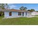 Cute light blue house with brown roof and well-manicured lawn at 11852 Se 71St Ct, Belleview, FL 34420