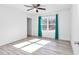 Bright bedroom with wood-look floors and teal curtains at 24440 Nw Falcon Ave, Dunnellon, FL 34431