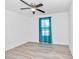 Simple bedroom with teal curtains, wood-look floors, and ceiling fan at 24440 Nw Falcon Ave, Dunnellon, FL 34431