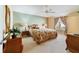 Spacious main bedroom with ceiling fan and wood furniture at 2467 Utica Way, The Villages, FL 32162