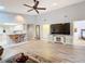 Open concept living area with kitchen, hardwood floors, and large TV at 5032 Se 108Th St, Belleview, FL 34420
