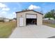 Tan metal workshop with roll-up door and concrete pad at 6292 Se 87Th St, Ocala, FL 34472