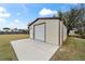 Tan metal workshop with roll-up door and concrete pad at 6292 Se 87Th St, Ocala, FL 34472
